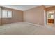 Spacious bedroom featuring neutral colors, large window with plantation shutters, and ensuite bath access at 29 Desert Highlands Dr, Henderson, NV 89052