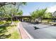 Community entrance featuring mature trees, a brick-paved driveway, and manicured landscaping at 29 Desert Highlands Dr, Henderson, NV 89052