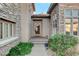 Elegant entry with stone facade and arched wood door at 29 Desert Highlands Dr, Henderson, NV 89052