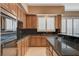 A kitchen features granite countertops, wood cabinets, stainless steel appliances, and a kitchen island at 29 Desert Highlands Dr, Henderson, NV 89052