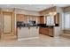 Well-equipped kitchen featuring a breakfast bar, wood cabinets, and tile flooring at 29 Desert Highlands Dr, Henderson, NV 89052