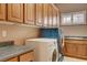 Well-lit laundry area featuring washer, dryer, sink, and ample cabinetry at 29 Desert Highlands Dr, Henderson, NV 89052