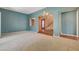 Bright living room featuring plush carpeting and a chandelier, seamlessly connected to the entryway and staircase at 29 Desert Highlands Dr, Henderson, NV 89052