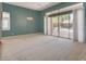 Spacious living room with carpet flooring and a sliding glass door providing access to the backyard pool area at 29 Desert Highlands Dr, Henderson, NV 89052