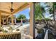 Comfortable seating on covered patio with a view of the pool and lush landscaping at 29 Desert Highlands Dr, Henderson, NV 89052
