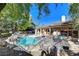 Backyard pool and patio area features a hammock, waterfall and lush landscaping, perfect for outdoor entertaining at 29 Desert Highlands Dr, Henderson, NV 89052