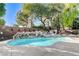 Lush backyard featuring a sparkling pool, cascading waterfall and mature landscaping at 29 Desert Highlands Dr, Henderson, NV 89052
