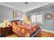 Bedroom with red and tan bedding, wood floors, and window shutters at 5100 Jordan Frey St # 203, Las Vegas, NV 89130