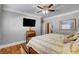 Main bedroom with hardwood floors, large TV, and ceiling fan at 5100 Jordan Frey St # 203, Las Vegas, NV 89130