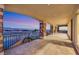 Expansive covered balcony with stone columns and wrought iron railing overlooks city lights at 5790 Aspen Falls Cir, Las Vegas, NV 89149