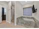 Bathroom features a standalone tub with granite surround and shower with glass door at 5790 Aspen Falls Cir, Las Vegas, NV 89149
