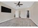 Spacious bedroom with a ceiling fan, tv and entryways to the bathroom and closet at 5790 Aspen Falls Cir, Las Vegas, NV 89149