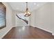 Spacious dining room with hardwood floors, an elegant chandelier, and an arched doorway at 5790 Aspen Falls Cir, Las Vegas, NV 89149