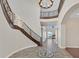 Grand foyer with a curved staircase and wrought iron railings, leading to an open-concept living space at 5790 Aspen Falls Cir, Las Vegas, NV 89149