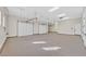 Massive garage featuring multiple doors and bright, overhead lighting at 5790 Aspen Falls Cir, Las Vegas, NV 89149