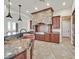 Gourmet kitchen features granite counters, custom cabinets, stone hood, and tile flooring at 5790 Aspen Falls Cir, Las Vegas, NV 89149
