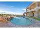 Inviting backyard pool area with rock waterfall and outdoor living space at 5790 Aspen Falls Cir, Las Vegas, NV 89149