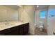 Bathroom with double sinks, dark cabinets, and a separate toilet and shower area at 7308 Davenbury St, Las Vegas, NV 89113