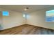 Bright bedroom featuring wood-look floors, light walls, and natural light from multiple windows at 7308 Davenbury St, Las Vegas, NV 89113