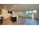 Expansive living area with modern floors, recessed lighting, and open kitchen concept with a central island at 7308 Davenbury St, Las Vegas, NV 89113