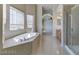 Bathroom with soaking tub, shower, and tile flooring at 9893 Cove Haven Ct, Las Vegas, NV 89178