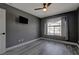 Bedroom with grey walls, wood-look floors, and ceiling fan at 10701 Penfolds St, Las Vegas, NV 89183