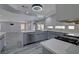 L-shaped kitchen with white cabinets, gray lower cabinets and a large island at 10701 Penfolds St, Las Vegas, NV 89183