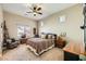 Spacious bedroom with ceiling fan, window seating, and striped bedding at 1336 Allegheny Moon Ter # 103, Henderson, NV 89002