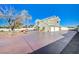 Two story house with a large driveway and mature tree at 1964 Westwind Rd, Las Vegas, NV 89146
