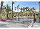 Gated community entrance with lush landscaping and palm trees at 2300 E Silverado Ranch Blvd # 1002, Las Vegas, NV 89183