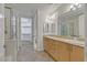 Bright bathroom with double vanity, tile flooring, walk-in closet, and glass-enclosed shower at 26 E Serene Ave # 124, Las Vegas, NV 89123