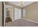 Bedroom with carpet, chandelier lighting, and access to hallway through sliding doors at 26 E Serene Ave # 124, Las Vegas, NV 89123