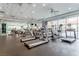Well-equipped gym featuring cardio machines, mirrors, ceiling fans, and large windows with neighborhood views at 26 E Serene Ave # 124, Las Vegas, NV 89123