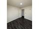 Bedroom featuring wood-look flooring, neutral walls and trim, and a paneled door leading to the hallway at 2900 Marlin Ave, Las Vegas, NV 89101