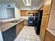 Bright kitchen with wood cabinets, black appliances, and a double sink at 3070 Tarpon Dr # 201, Las Vegas, NV 89120