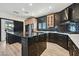 Modern kitchen with black and light wood cabinets, granite island, and stainless steel appliances at 3738 Falcon Springs Dr, Las Vegas, NV 89147