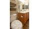 This bathroom features wood-look flooring, a toilet, and wooden cabinets at 4625 Centisimo Dr # 202, North Las Vegas, NV 89084