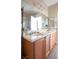 Bathroom featuring double sinks, wood cabinetry, and a large mirror at 4625 Centisimo Dr # 202, North Las Vegas, NV 89084