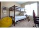 This bedroom features a wooden bunk bed with a bright yellow beanbag chair and a large window at 4625 Centisimo Dr # 202, North Las Vegas, NV 89084