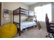 Comfortable bedroom with a wooden bunk bed, yellow bean bag chair, and neutral decor at 4625 Centisimo Dr # 202, North Las Vegas, NV 89084