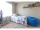 This bedroom features carpet, a bright window, and a blue beanbag chair at 4625 Centisimo Dr # 202, North Las Vegas, NV 89084