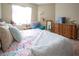 Cozy bedroom featuring floral bedding, a dresser, a comfortable blue chair, and natural light at 4625 Centisimo Dr # 202, North Las Vegas, NV 89084