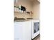 A laundry room with a modern washer and dryer set, complete with overhead shelving at 4625 Centisimo Dr # 202, North Las Vegas, NV 89084