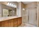 Well-lit bathroom featuring a double vanity, large mirror, and glass-enclosed shower at 5201 Progresso St, Las Vegas, NV 89135