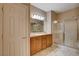 Well-lit bathroom featuring a double vanity, large mirror, and glass-enclosed shower at 5201 Progresso St, Las Vegas, NV 89135