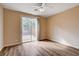 Bright bedroom features wood floors, ceiling fan, and sliding glass doors to the outside at 5201 Progresso St, Las Vegas, NV 89135