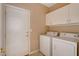 This laundry room is equipped with a washer, dryer, and overhead storage cabinets at 5201 Progresso St, Las Vegas, NV 89135