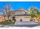 Two-story house with beige exterior, two-car garage, and landscaping at 5423 San Florentine Ave, Las Vegas, NV 89141