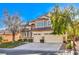 Beige two-story house with a three-car garage and mature trees at 5423 San Florentine Ave, Las Vegas, NV 89141