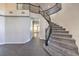 Grand curved staircase with dark wood railing and gray carpeting at 5423 San Florentine Ave, Las Vegas, NV 89141